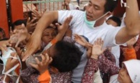 Relawan membagikan masker kepada siswa sekolah dasar (SD) di Alanglaweh, Padang, Sumatera Barat, Kamis (8/10).