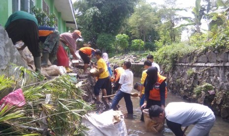 Relawan membantu membersihkan sekolah binaan Rumah Zakat yang terkena banjir.