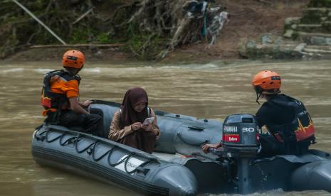 Relawan membantu siswa menyeberangi Sungai Cimadur di Sukajaya, Lebak, Banten, Jumat (14/10/2022). Bencana banjir bandang yang mengakibatkan terputusnya akses jembatan di daerah tersebut pada Selasa (11/10/2022), mengharuskan warga menyeberangi sungai menggunakan perahu karet. 