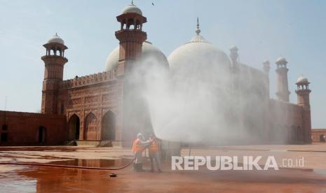 Pakistan Kerahkan 3.000 Polisi Jaga Masjid. Relawan memberikan disinfektan di area Masjid Badshahi yang bersejarah menjelang bulan suci Ramadhan di Lahore, Pakistan.