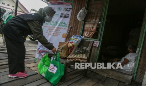 Relawan memberikan paket sembako kepada warga yang menjalankan isolasi mandiri (isoman) karena COVID-19 di Palangkaraya, Kalimantan Tengah, Jumat (13/8/2021). Aksi bakti sosial dengan membagikan sembako dan vitamin yang diadakan Puskesmas Bukit Hindu bersama sejumlah relawan di kota itu sebagai bentuk kepedulian untuk membantu warga yang sedang isoman akibat terdampak Covid-19. (ilustrasi)