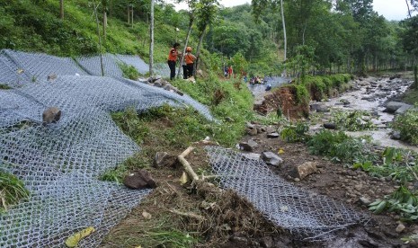 Relawan memperbaiki jalan di bantaran Sungai Jompo/Kalijompo yang tergerus banjir bandang dari Pegunungan Argopuro di Desa Klungkung, Sukorambi, Jember, Jawa Timur, Minggu (2/2/2020). Pemprov Jawa Timur mewaspadai potensi banjir bandang di kawasan sekitar tujuh gunung di Jatim yang musim kemarau lalu mengalami kebakaran hutan dan lahan, seperti Pegunungan Argopuro, Raung, Panderman, Semeru, Arjuno, Ijen juga Welirang. 