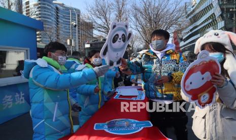 Relawan mengacungkan maskot Olimpiade Musim Dingin 2022 untuk dijadikan objek foto bersama warga di kawasan Sanlitun, Beijing, China, Senin (31/12022). Olimpiade Musim Dingin Beijing digelar pada 4-20 Februari 2022 yang bersamaan dengan musim libur panjang Tahun Baru Imlek. 