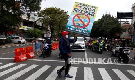 Relawan mengusung poster bertuliskan Terima Kasih Anda Tidak Mudik saat aksi di Jalan Slamet Riyadi, Solo, Jawa Tengah, Rabu (5/5/2021). Aksi tersebut sebagai bentuk apresiasi kepada perantau yang tidak mudik di Solo pada Lebaran 2021 dan mennghimbau masyakarakat agar tetap waspada virus COVID-19 dengan menjalankan protokol kesehatan ketika beraktivitas keseharian.