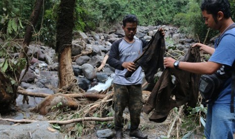 Relawan menunjukan baju korban banjir bandang di aliran Sungai Lau Mentar, Sibolangit, Deli Serdang, Sumatera Utara, Selasa (17/5).