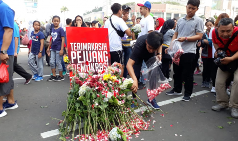 Relawan milenial Jokowi-Ma'ruf mengadakan aksi doa dan tabur bunga pada Ahad, (28/4) di kawasan bundaran HI Jakarta. Mereka mendoakan para penyelenggara pemilu yang sakit dan meninggal selama pemilu serentak 2019. 