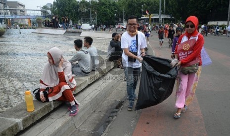  Relawan peduli Jakarta Bersih membersihan sampah yang berserakan di kawasan Hari Bebas Kendaraan Bermotor (HBKB) di Bundaran HI, Jakarta, Ahad (20/12). (Republika/Yasin Habibi)