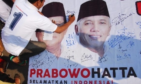 Relawan pendukung Prabowo-Hatta yang tergabung dalam Komunitas Masyarakat Penyelamat Indonesia (KOMPI) membubuhkan tanda tangan pada sebuah spanduk sebelum melakukan pawai dan aksi long march menuju Taman Ismail Marzuki, Jakarta, Sabtu (7/6).