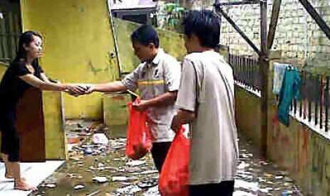 Relawan PKS sambangi rumah korban banjir untuk memberikan bantuan sarapan pagi berupa bubur dan teh manis.