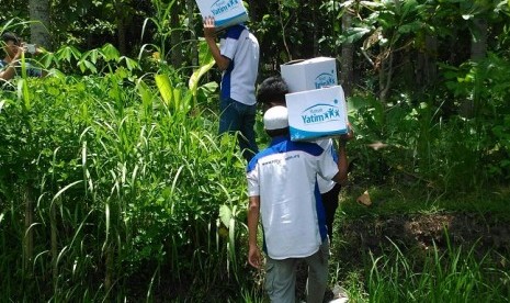 Relawan Rumah Yatim tengah mengangkut paket santunan untuk mustahik di Dusun Kepek, Desa Banyusoco, Kecamatan Playen, Kabupaten Gunungkidul, Daerah Istimewa Yogyakarta, belum lama ini.  