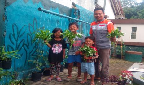 Relawan Rumah Zakat mengajak anak-anak untuk memanen hasil budaya tanaman pangan.