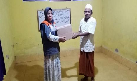 Relawan Rumah Zakat menyalurkan bantuan Alquran di TPQ Darussholihah Pantung, Desa Darmaji.