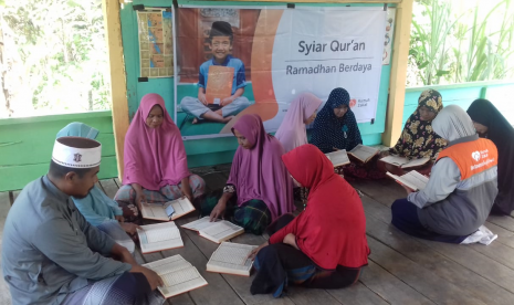 Relawan Rumah Zakat menyalurkan paket Syiar Quran kepada anak-anak dan ibu-ibu di Desa Guha Uleue, Aceh Utara.