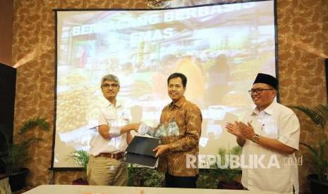 Religion Head IV Mandiri Syariah Jeffry Prayanan (berbatik), Dirut PD Pasar Bermartabat Bandung Ervan Maksum (kiri) Disaksikan Wakil Wali Kota Bandung Oded M Danial (kanan) memperlihatkan dokumen kesepakatan usai penandatanganan kerjasama Bank Syariah Mandiri dengan PD Pasar Bermartabat Bandung, di Kota Bandung, Selasa (7/8). 