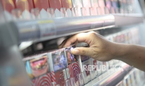 Rencana Kenaikan Harga Rokok. Petugas toko mengambil rokok untuk konsumen di salah satu ritel. 