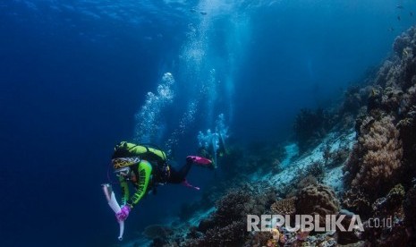 Tri Tito Karnavian saat membawa replika obor Asian Games di Hidden Bay Piaynemo, Raja Ampat, Papua Barat. 