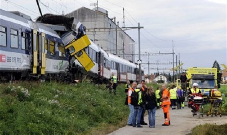 Rescue personnel work at the site where two passenger trains collided head-on in Granges-pres-Marnand, western Switzerland, Monday, July 29, 2013. Police say at least 44 people were injured, four of them seriously. 