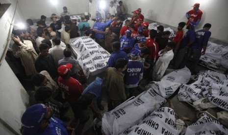 Rescue workers and residents gather at the morgue to identify relatives after a bomb blast in a residential area in Karachi March 3, 2013. 