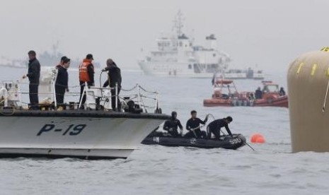 Rescue workers install floats where the capsized passenger ship ''Sewol'' sank during the rescue operation in the sea off Jindo April 18, 2014.