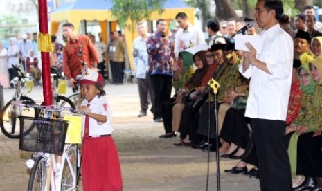 residen Joko Widodo (kanan) membagikan sepeda pada pelajar (Ilustrasi).