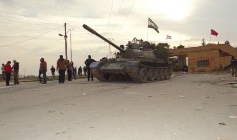 Residents and Free Syrian Army fighters pose near a tank after the fighters said they fought and defeated government troops from the town of Ras al-Ain, near the province of Hasaka, 600 km (375 miles) from Damascus, November 22, 2012.  