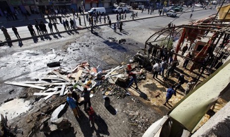 Residents gather at the site of a car bomb attack in the AL-Mashtal district in Baghdad March 19, 2013. 