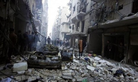 Para warga sipil melihat puing-puing reruntuhan di Aleppo, Suriah, usai serangan udara yang dilancarkan rezim Bashar Al Assad.