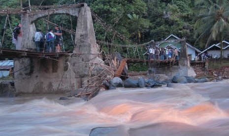 Residents watch the impact of flood from the bridge in Batu Busuk village, Padang, West Sumatra.  