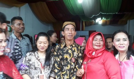 Reza Sri Mulyadi (tengah) yang merupakan orang mirip Presiden Joko Widodo menjadi sasaran selfie saat menghadiri acara pernikahan Bobby Nasution-Kahiyang Ayu di Medan, Ahad (26/11).