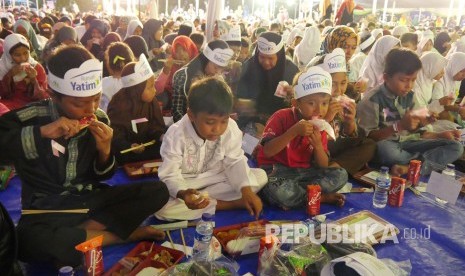 Ribuan anak menikmati hidangan saat buka puasa bersama pada acara Iftihar Indonesia Bersama 6000 Yatim, Yang digelar Rumah Yatim, di Lapangan Gasmin, Antapani, Kota Bandung, Sabtu (25/5).