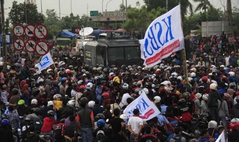 Ribuan buruh gabungan dari berbagai perusahaan berkumpul di depan gerbang Tol Jakarta-Merak KM-57, Ciujung, Serang, Banten, Selasa (3/12).  (Antara/Asep Fathulrahman)