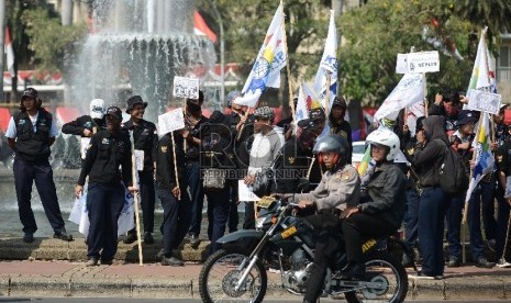  Ribuan buruh melakukan aksi di bundaran Patung Kuda, Silang Monas, Jakarta Pusat, Selasa (1/9). 