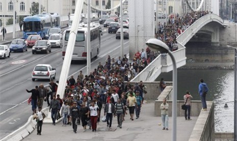 Ribuan imigran melintasi Jembatan Elizabeth di atas Sungai Danube dalam perjalanan menuju Austria dari stasiun kereta Keleti di Budapest, Hungaria, Sabtu (5/9).