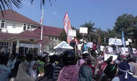 Ribuan Massa yang terdiri dari pedangan pasar Sumber, warga komunitas tukang ojek dan tukang becak, sopir angkot, karang taruna dan mahasiswa demo ke kantor Bupati Cirebon, Senin (28/3).(Republika/Lilis Sri Handayani)