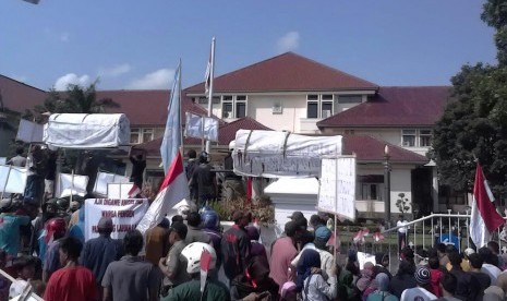 Ribuan Massa yang terdiri dari pedangan pasar Sumber, warga komunitas tukang ojek dan tukang becak, sopir angkot, karang taruna dan mahasiswa demo ke kantor Bupati Cirebon, Senin (28/3).(Republika/Lilis Sri Handayani)