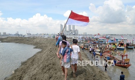 Ribuan nelayan bersama LSM melakukan aksi simbolis dengan menyegel pulau G proyek reklamasi di kawasan Muara Angke, Jakarta Utara, Ahad (17/4).