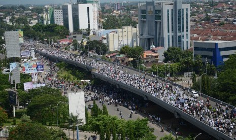 Ribuan orang berjalan saat berunjuk rasa di atas jalan jembatan layang menuju kantor Gubernur Sulsel di Makassar, Jumat (4/10). 