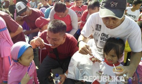 Ribuan pasangan ayah dan anak di Kota Sukabumi melakukan gosok gigi massal di Lapangan Merdeka, Kota Sukabumi, Ahad (12/3). Kegiatan tersebut digelar dalam rangka meningkatkan pemahaman anak dan orangtua mengenai pentingnya memelihara kesehatan gigi.