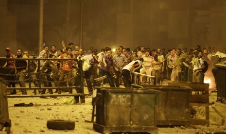 Ribuan pendukung Presiden Muhammad Mursi terlibat bentrok dengan polisi saat berunjuk rasa menolak kudeta militer di pusat kota Kairo, Senin (15/7).     (AP/Hussein Malla)