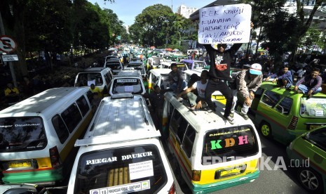 Ribuan sopir angkutan kota (angkot) dan taksi Kota Bandung melakukan aksi unjuk rasa dan mogok massal di depan Gedung Sate, Jalan Diponegoro, Kota Bandung, Kamis (9/3).