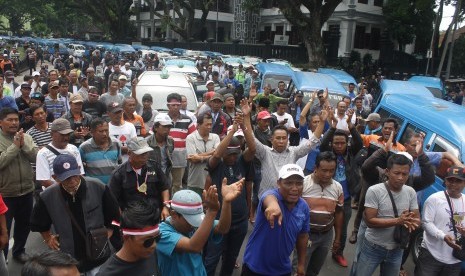 Ribuan supir angkutan melakukan mogok massal dan berunjuk rasa menolak keberadaan transportasi berbasis aplikasi online di depan Balaikota Malang, Jawa Timur, Selasa (26/9). 