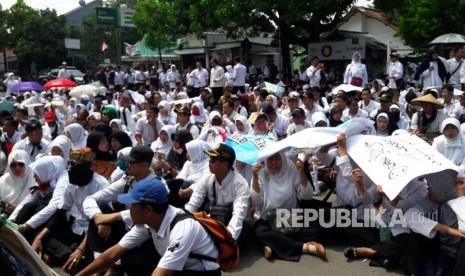 Ribuan tenaga honorer yang tergabung dalam Forum Honorer Kabupaten Indramayu menggelar unjuk rasa di depan gedung DPRD Indramayu, Senin (20/11). 