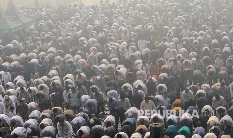 Ribuan umat muslim melaksanakan Sholat Idul Adha di halaman Masjid Raya Annur dengan kondisi kabut asap karhutla yang menyelimuti Kota Pekanbaru, Riau, Minggu (11/8). Kabut asap dampak dari kebakaran hutan dan lahan yang masih terjadi di Provinsi Riau membuat kota Pekanbaru dan beberapa kabupaten lainya diselimuti kabut asap khususnya pada pagi hari. 