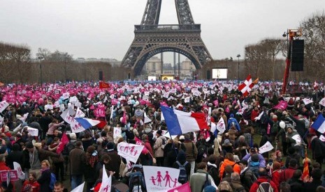   Ribuan warga berunjuk rasa di Champ de Mars dekat Menara Eiffel memprotes rencana legalisasi pernikahan sesama jenis di Paris, Ahad (13/1).  (Reuters/Charles Platiau) 