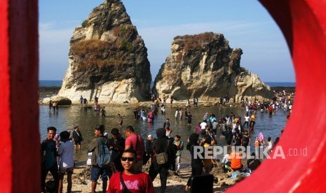 Wisatawan bermain di pantai Tanjung Layar, Sawarna, Lebak, Banten. 