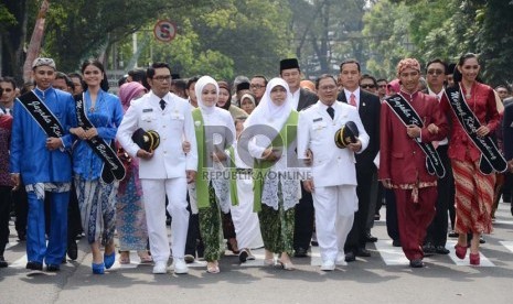    Ridwan Kamil (kiri) dan Oden M Danial (kanan) beserta istri berjalan kaki dari hotel menuju Gedung DPRD Kota Bandung untuk mengikuti upacara pelantikan Wali Kota dan Wakil Wali Kota Bandung, Senin (16/9).    (Republika/Edi Yusuf)