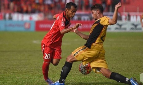 Riko Simanjuntak (kiri) saat berusaha melewati pemain Mitra Kukar. Riko merupakan pencetak gol pembuka dari kemenangan Semen Padang 3-2 atas Mitra Kukar, Senin (12/12).