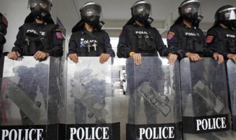 Riot police officers, wearing gas masks, stand with their shields during a demonstration for the media at the Royal Thai Police Sport Club in Bangkok January 7, 2014.