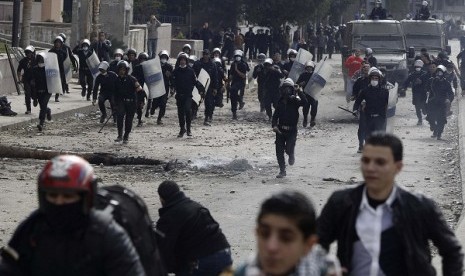 Riot police run towards protesters opposing Egyptian President Mohamed Mursi during clashes, along Qasr Al Nil bridge, which leads to Tahrir Square in Cairo January 28, 2013. 