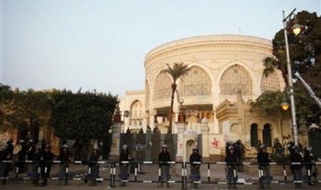 Riot police stand guard in front of the presidential palace in Cairo December 16, 2012.  